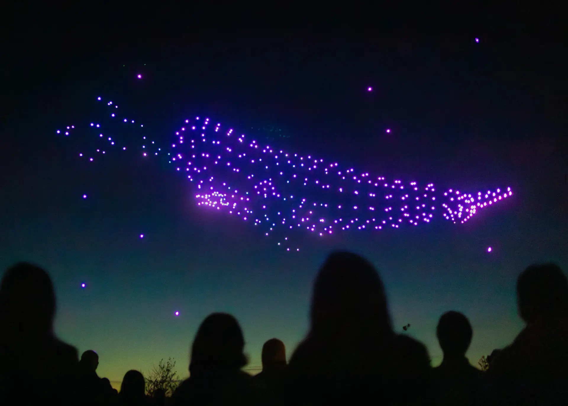 Des drones formant une baleine dans un ciel étoilé